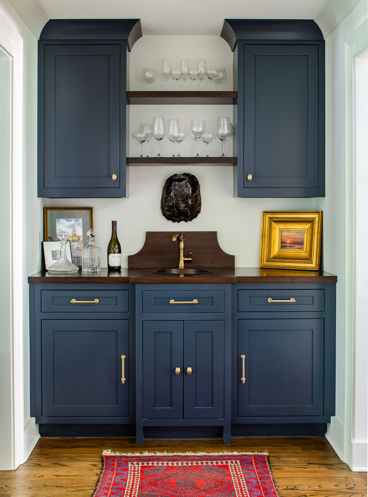 Klassisk inredning av en bruna linjär brunt hemmabar med vask, med en undermonterad diskho, skåp i shakerstil, blå skåp, träbänkskiva och mellanmörkt trägolv