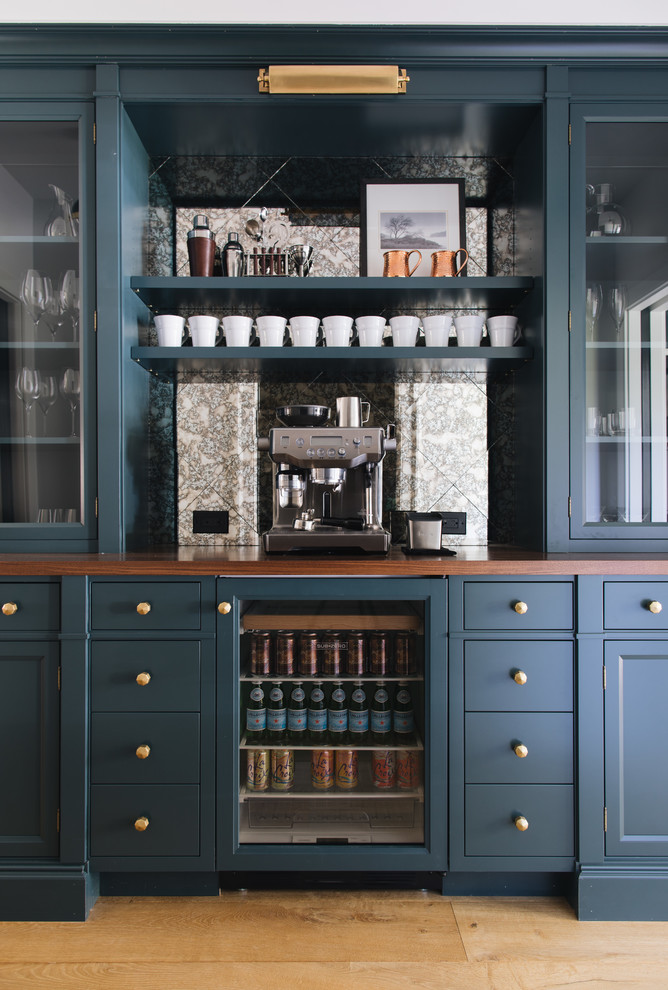 Inspiration för mellanstora klassiska linjära brunt hemmabarer, med luckor med infälld panel, blå skåp och träbänkskiva