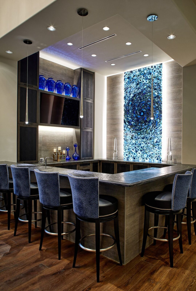 Photo of a contemporary u-shaped home bar in Houston with beige splashback, medium hardwood flooring, brown floors and black worktops.