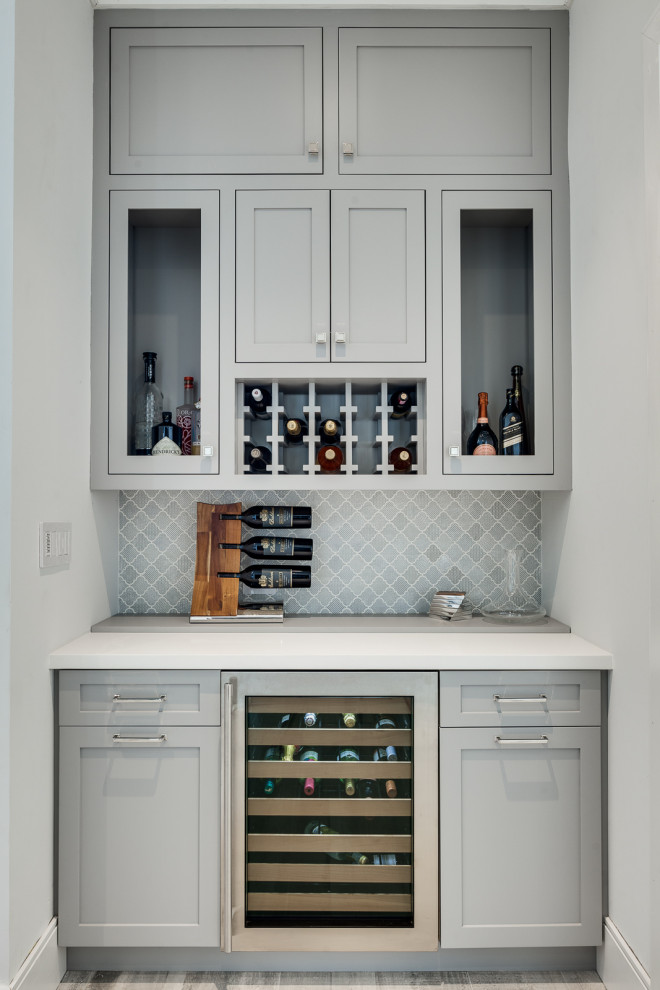 Small coastal single-wall wet bar in Miami with grey cabinets, tile countertops, grey splashback, mosaic tiled splashback, grey floors, white worktops, shaker cabinets and porcelain flooring.