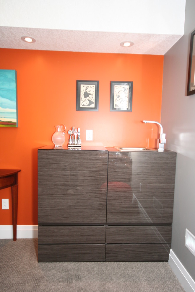 Example of a small minimalist single-wall wet bar design in Toronto with a drop-in sink, flat-panel cabinets, gray cabinets and glass countertops