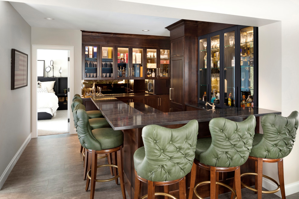 Esempio di un angolo bar classico con ante con riquadro incassato, ante in legno bruno, pavimento marrone e top nero
