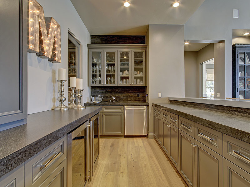Design ideas for a large traditional galley breakfast bar in Sacramento with a submerged sink, beaded cabinets, grey cabinets, engineered stone countertops, brown splashback, stone tiled splashback, light hardwood flooring and beige floors.