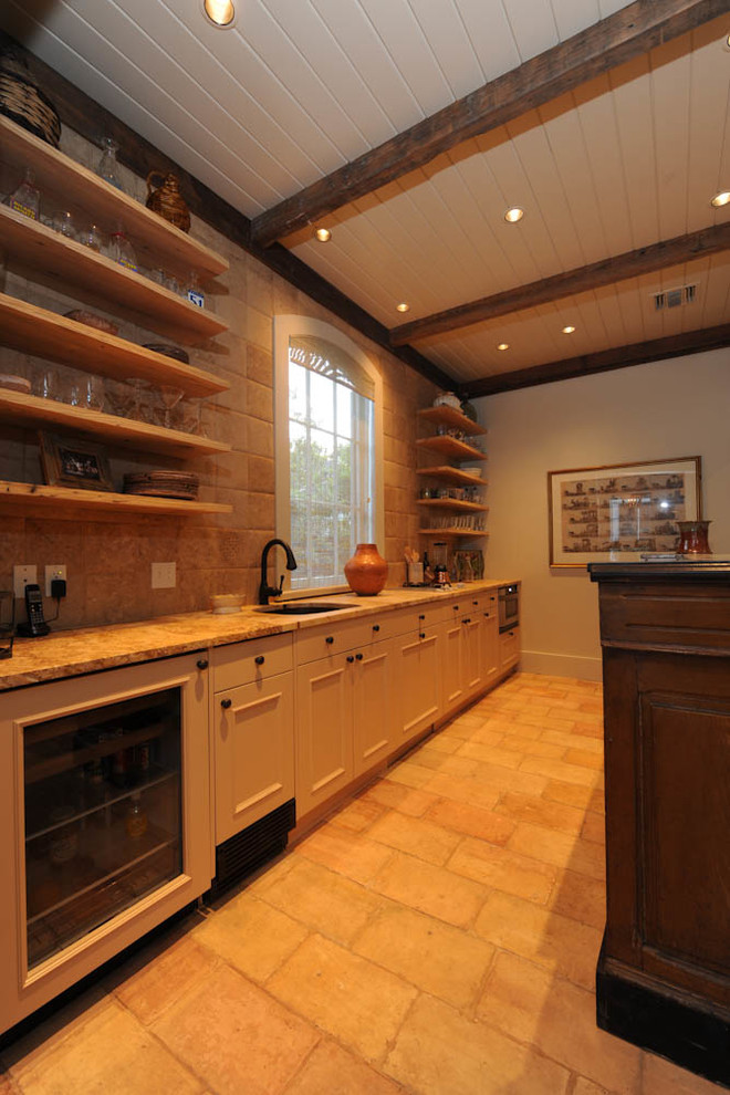This is an example of a medium sized rustic galley wet bar in New Orleans with a submerged sink, open cabinets, light wood cabinets, granite worktops, beige splashback, terracotta splashback and terracotta flooring.