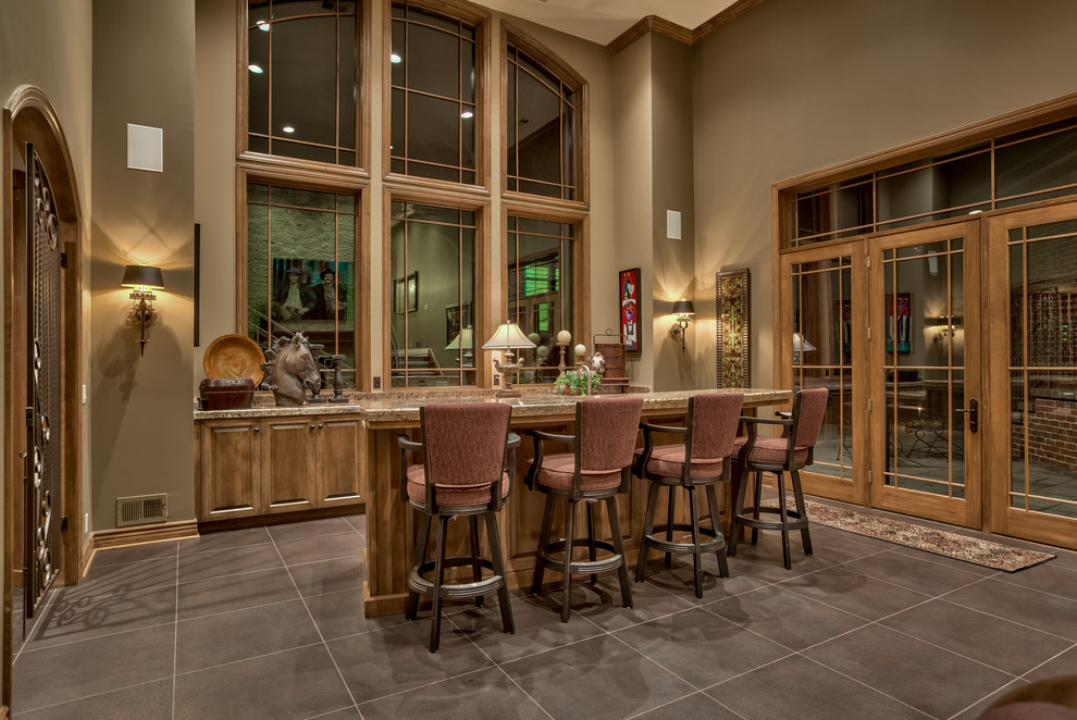 Imagen de bar en casa con barra de bar de galera tradicional con armarios con paneles con relieve, puertas de armario de madera oscura y salpicadero marrón