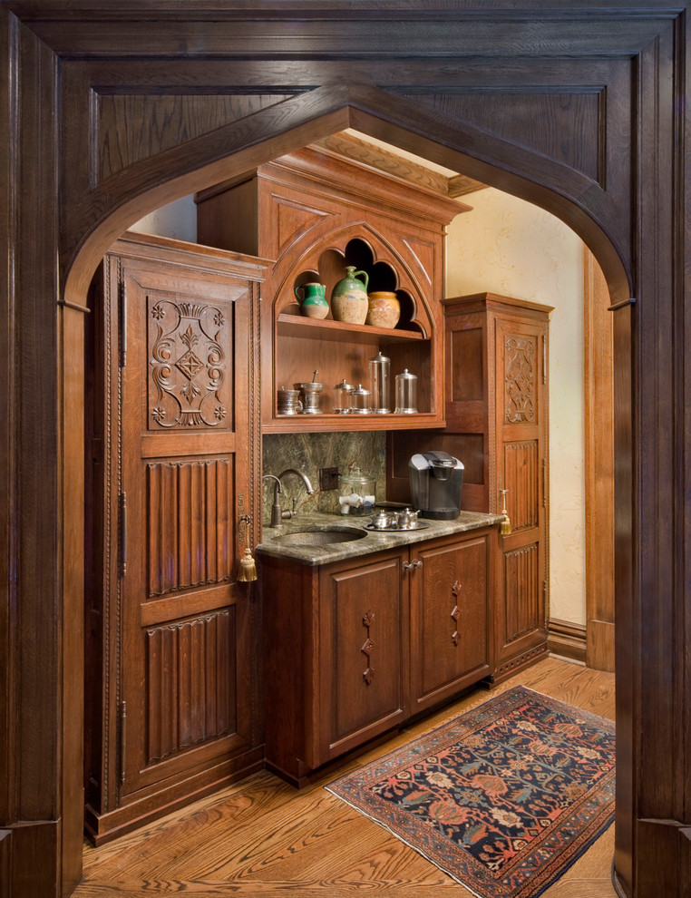 This is an example of a medium sized victorian single-wall wet bar in Charlotte with raised-panel cabinets.