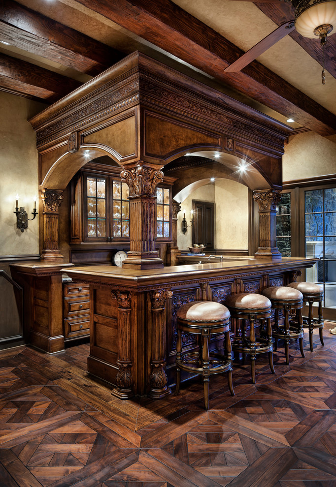 Пример оригинального дизайна: п-образный домашний бар в классическом стиле с барной стойкой, фасадами с выступающей филенкой, темными деревянными фасадами и темным паркетным полом