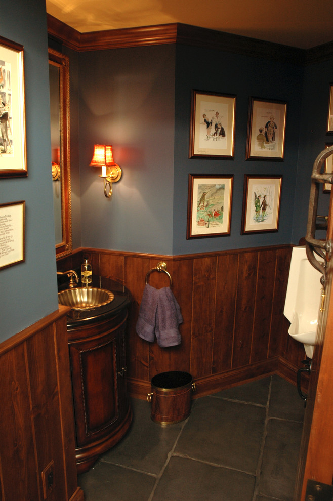 Ejemplo de bar en casa con barra de bar clásico grande con armarios con rebordes decorativos, puertas de armario de madera en tonos medios y suelo de pizarra