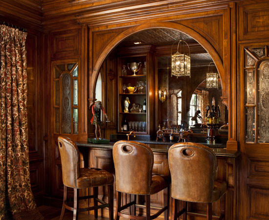 На фото: домашний бар в классическом стиле с фасадами с выступающей филенкой, темными деревянными фасадами, коричневым фартуком, темным паркетным полом и коричневым полом