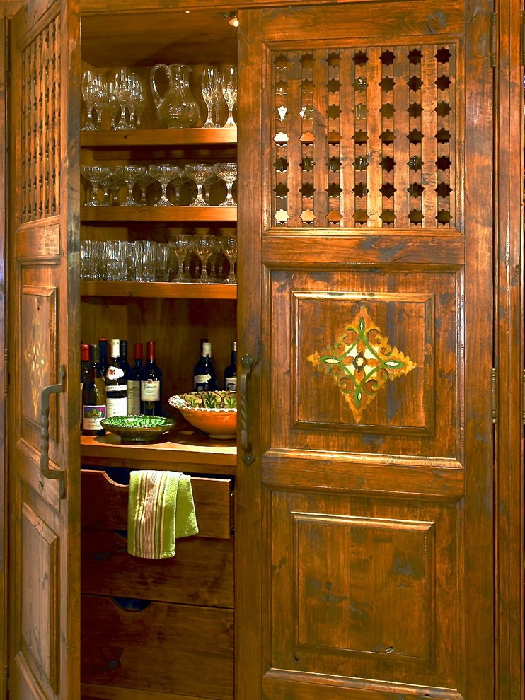 На фото: домашний бар в средиземноморском стиле с фасадами с выступающей филенкой и фасадами цвета дерева среднего тона
