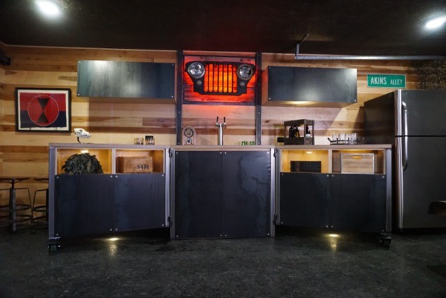 Immagine di un angolo bar con lavandino rustico di medie dimensioni con nessun lavello, ante lisce, paraspruzzi marrone, paraspruzzi in legno, pavimento in laminato e pavimento nero
