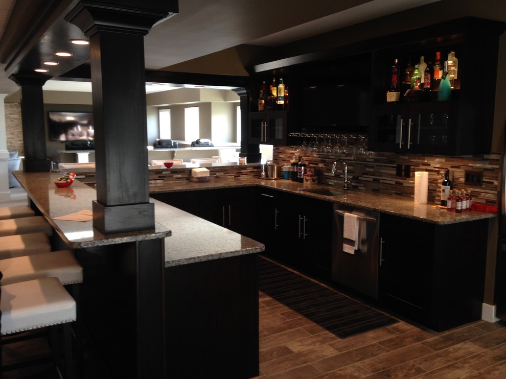 Example of a large arts and crafts u-shaped porcelain tile seated home bar design in Detroit with an undermount sink, shaker cabinets, dark wood cabinets, granite countertops and multicolored backsplash