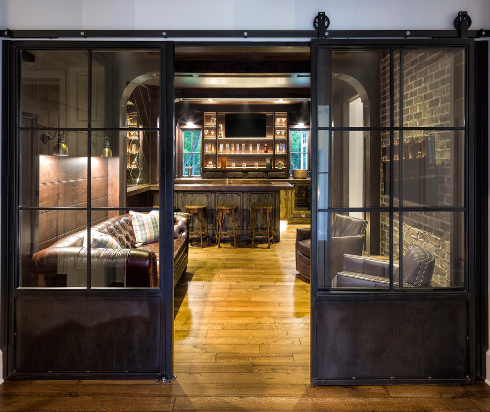 Immagine di un grande angolo bar con lavandino tradizionale con ante lisce, ante con finitura invecchiata, pavimento in legno massello medio e top marrone