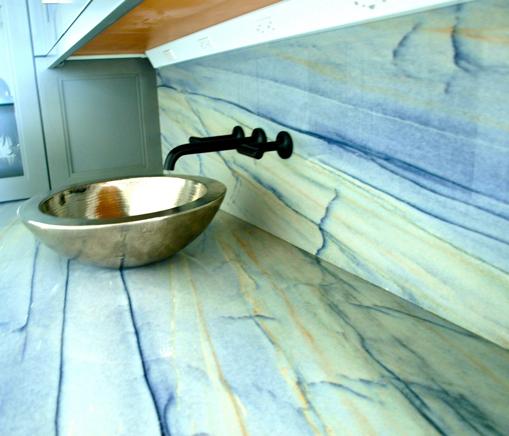 Exempel på en liten klassisk lila l-formad lila hemmabar med vask, med luckor med glaspanel, grå skåp, granitbänkskiva, flerfärgad stänkskydd, stänkskydd i sten, ljust trägolv och grått golv