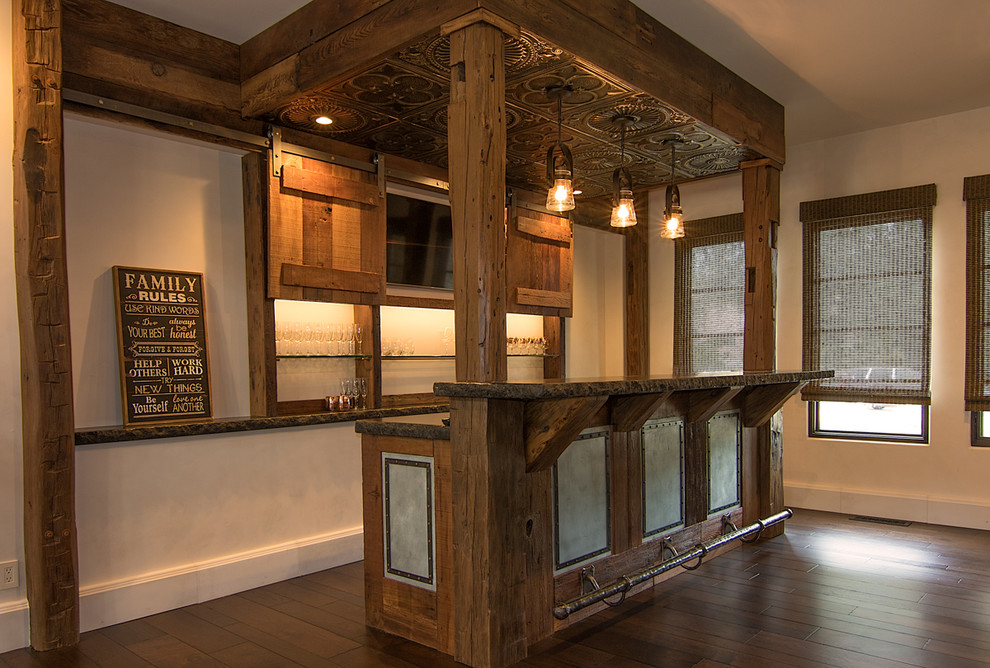 Exemple d'un bar de salon parallèle méditerranéen en bois vieilli de taille moyenne avec des tabourets, un plan de travail en granite et parquet foncé.