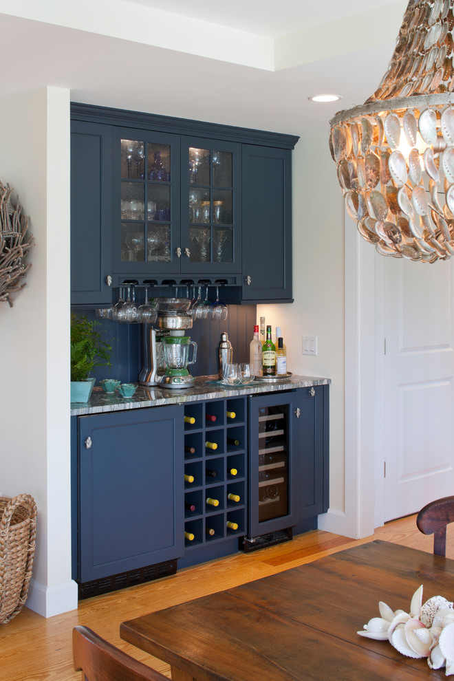 Modern inredning av en mellanstor linjär hemmabar med vask, med luckor med infälld panel, blå skåp, bänkskiva i kvartsit, blått stänkskydd, stänkskydd i trä, ljust trägolv och brunt golv