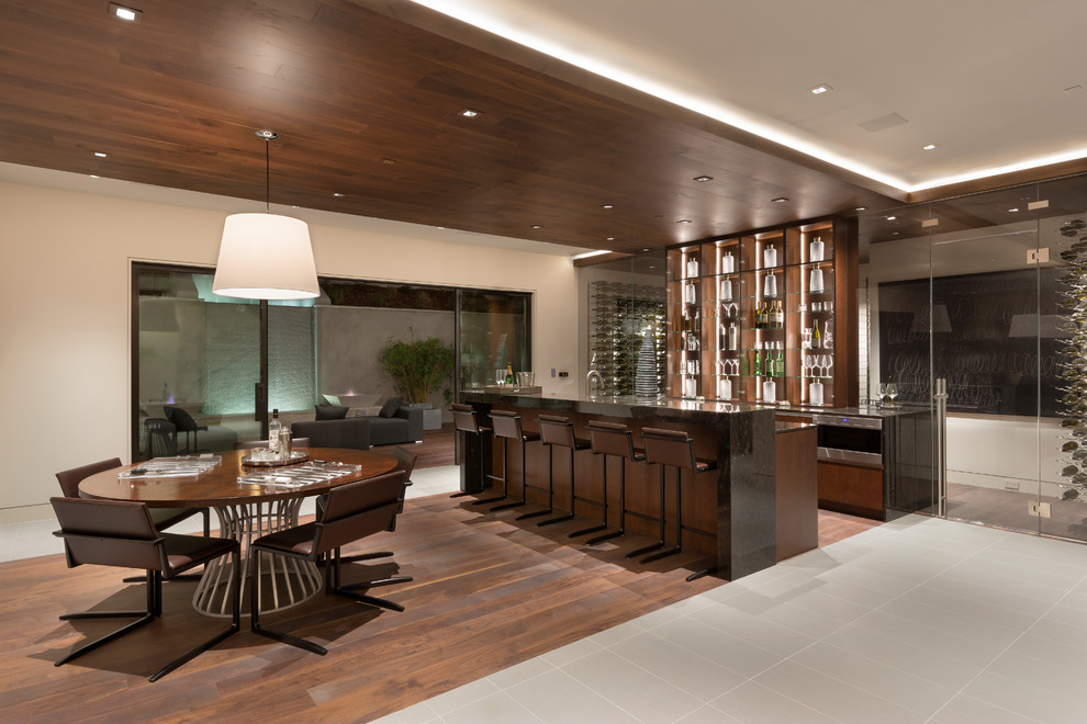 Design ideas for a contemporary galley breakfast bar in Orange County with dark hardwood flooring, brown floors and black worktops.