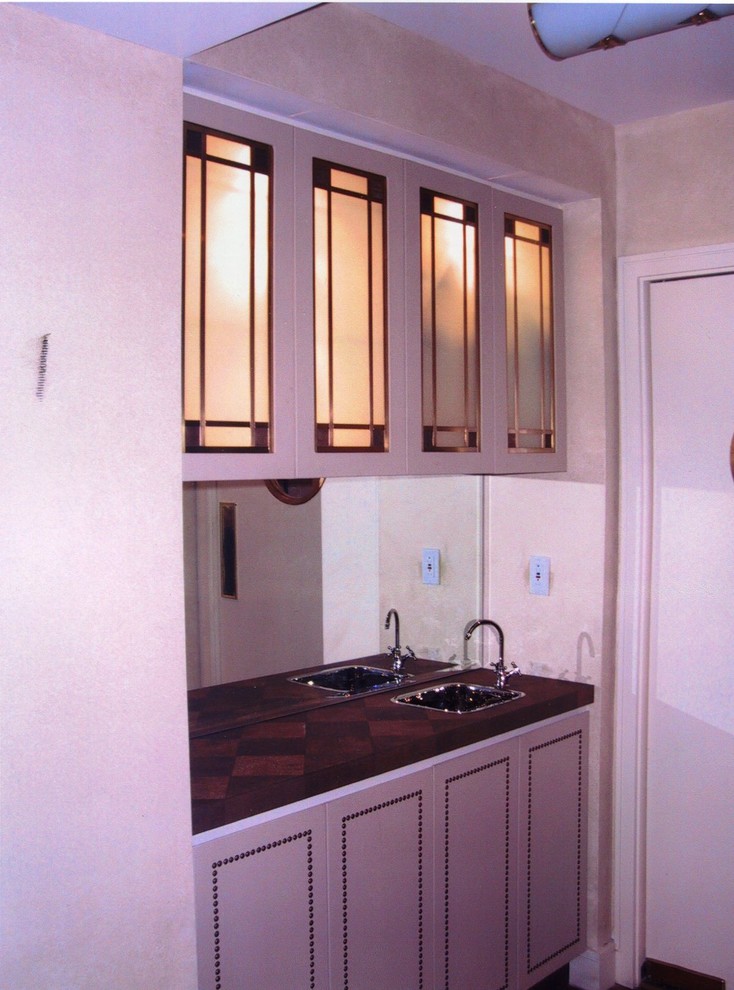Exemple d'un très grand bar de salon avec évier linéaire avec un évier posé, un placard à porte vitrée, des portes de placard beiges, un plan de travail en cuivre, une crédence miroir et un sol en bois brun.
