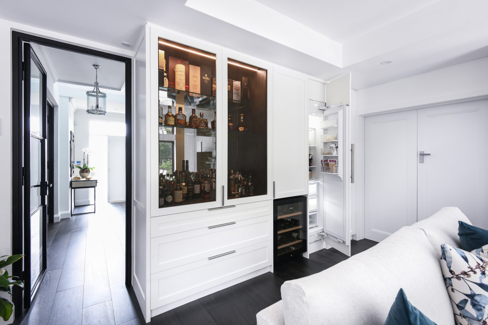 Diseño de bar en casa moderno pequeño con armarios estilo shaker, puertas de armario blancas, encimera de mármol, salpicadero con efecto espejo, suelo de madera oscura, suelo negro y encimeras negras