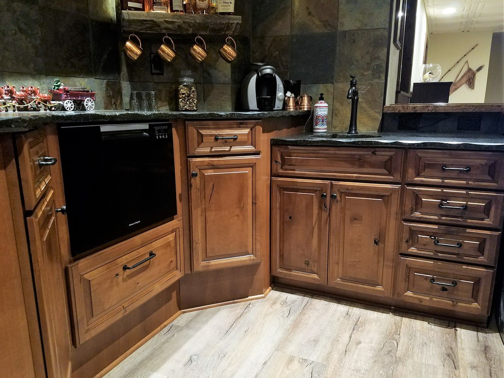 This is an example of a medium sized rustic galley wet bar in Other with a submerged sink, raised-panel cabinets, medium wood cabinets, granite worktops, multi-coloured splashback, slate splashback, vinyl flooring and multi-coloured floors.