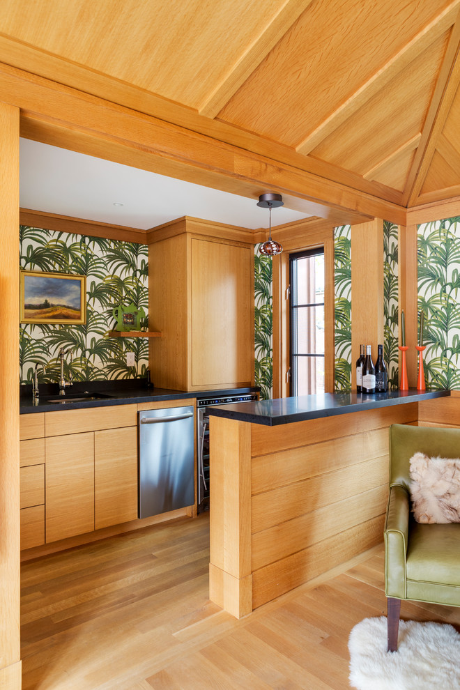 Immagine di un angolo bar con lavandino tropicale con lavello sottopiano, ante lisce, ante in legno chiaro, parquet chiaro e pavimento beige
