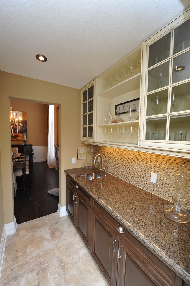 Medium sized traditional single-wall home bar in Toronto with a submerged sink, glass-front cabinets, beige cabinets, granite worktops, brown splashback, mosaic tiled splashback, porcelain flooring and beige floors.