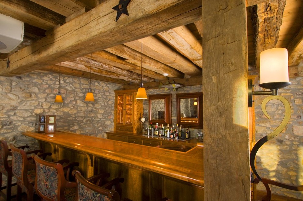 Foto di un bancone bar country con ante con riquadro incassato, ante in legno chiaro e parquet chiaro