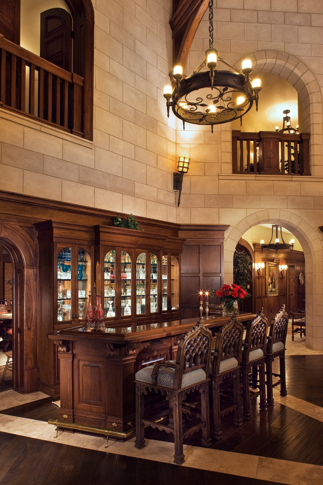 Esempio di un grande bancone bar tradizionale con ante in legno bruno, top in legno, ante di vetro e parquet scuro