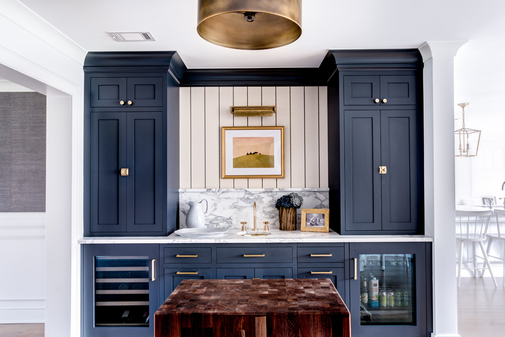 Example of a transitional single-wall wet bar design in New York with an undermount sink, shaker cabinets, blue cabinets, marble countertops, white backsplash and marble backsplash