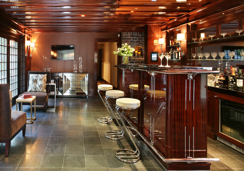 Esempio di un grande bancone bar tradizionale con nessun'anta, ante in legno bruno, paraspruzzi a specchio, lavello sottopiano, pavimento in ardesia e pavimento grigio
