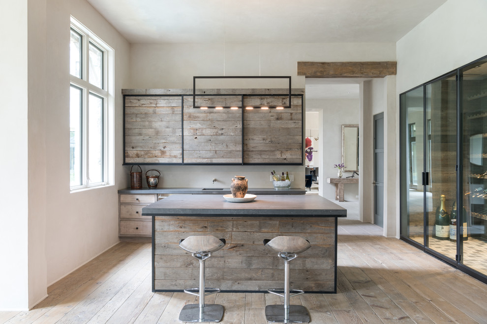 This is an example of a large farmhouse breakfast bar in Houston with distressed cabinets, concrete worktops, light hardwood flooring, a submerged sink and beige floors.