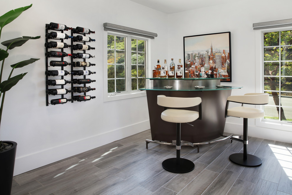 Inspiration for a large contemporary l-shaped gray floor seated home bar remodel in Orange County with glass countertops and dark wood cabinets