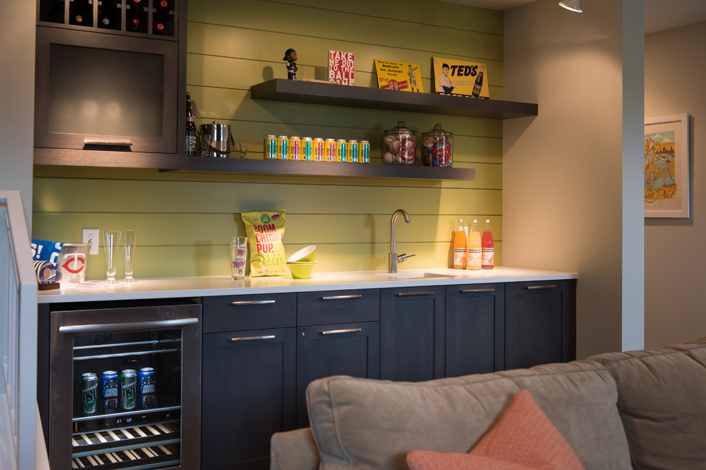 Imagen de bar en casa con fregadero lineal retro con fregadero bajoencimera, armarios estilo shaker, puertas de armario negras, salpicadero verde y encimeras blancas