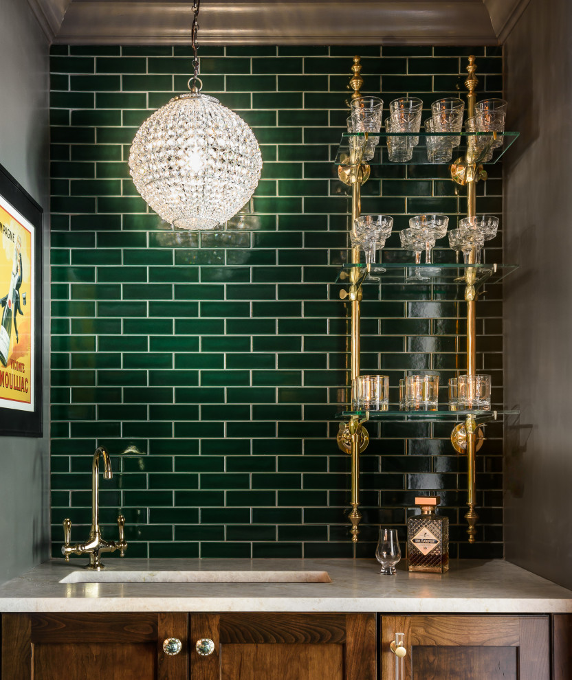 Photo of a classic home bar in St Louis with shaker cabinets, green splashback, metro tiled splashback and brown floors.