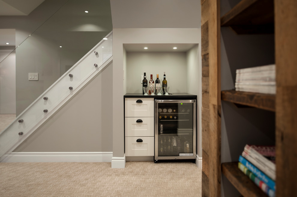 Small contemporary single-wall wet bar in Toronto with carpet, beige floors, no sink, white cabinets, engineered stone countertops and shaker cabinets.