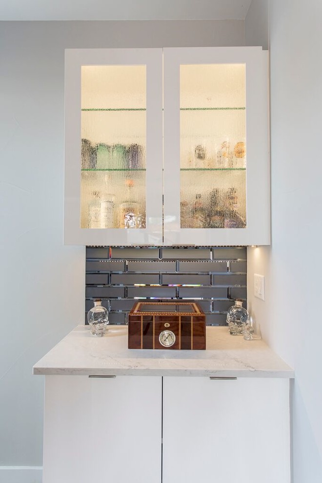 Imagen de bar en casa lineal actual pequeño con armarios con paneles lisos, puertas de armario blancas, encimera de cuarcita, salpicadero azul y salpicadero de azulejos de vidrio