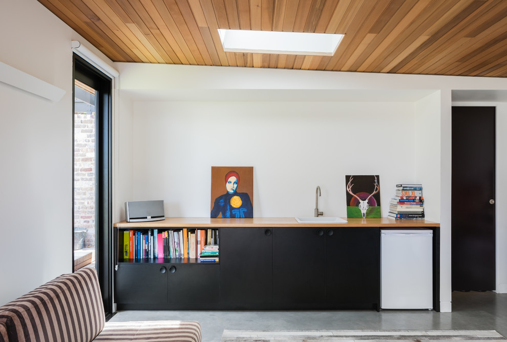 シドニーにある低価格の小さなコンテンポラリースタイルのおしゃれなウェット バー (I型、ドロップインシンク、フラットパネル扉のキャビネット、黒いキャビネット、木材カウンター、コンクリートの床、グレーの床、ベージュのキッチンカウンター) の写真