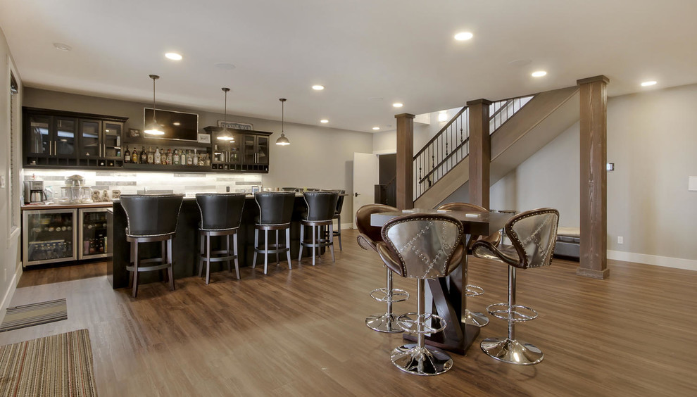 Example of a large transitional single-wall dark wood floor and brown floor wet bar design in Edmonton with glass-front cabinets, dark wood cabinets, multicolored backsplash and stone tile backsplash