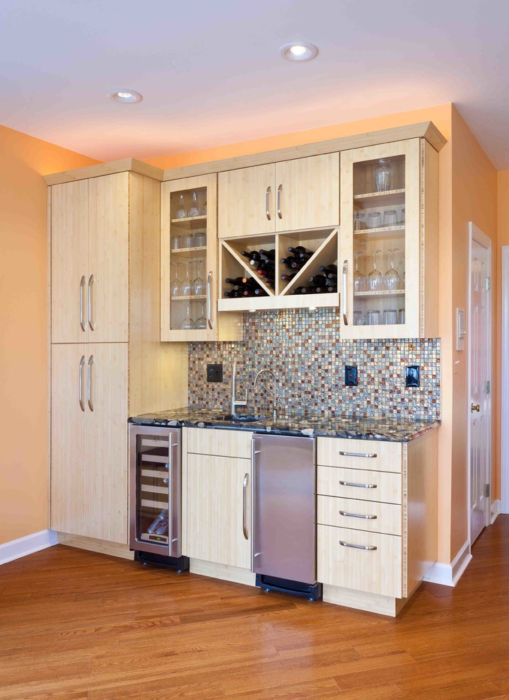 Inspiration for a mid-sized transitional single-wall bamboo floor wet bar remodel in Baltimore with an undermount sink, flat-panel cabinets, light wood cabinets, granite countertops, multicolored backsplash and glass tile backsplash