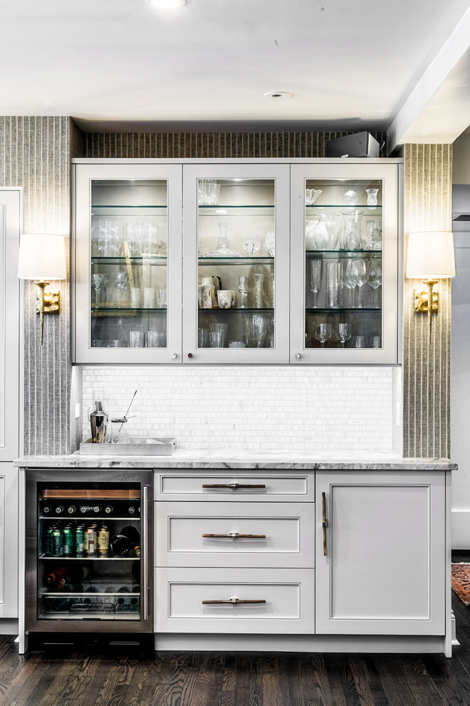 Wet bar - mid-sized transitional single-wall dark wood floor and brown floor wet bar idea in Chicago with no sink, glass-front cabinets, white cabinets, granite countertops, white backsplash and stone tile backsplash