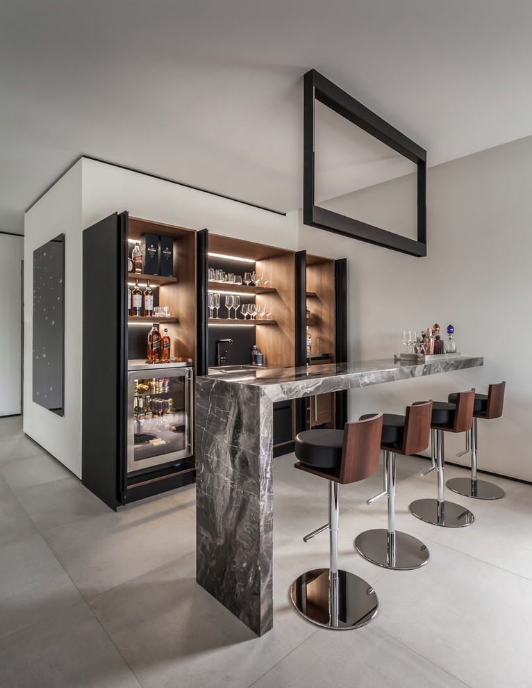 Inspiration for a large contemporary galley porcelain tile and gray floor wet bar remodel in Miami with dark wood cabinets, marble countertops, a drop-in sink, black backsplash, gray countertops and open cabinets