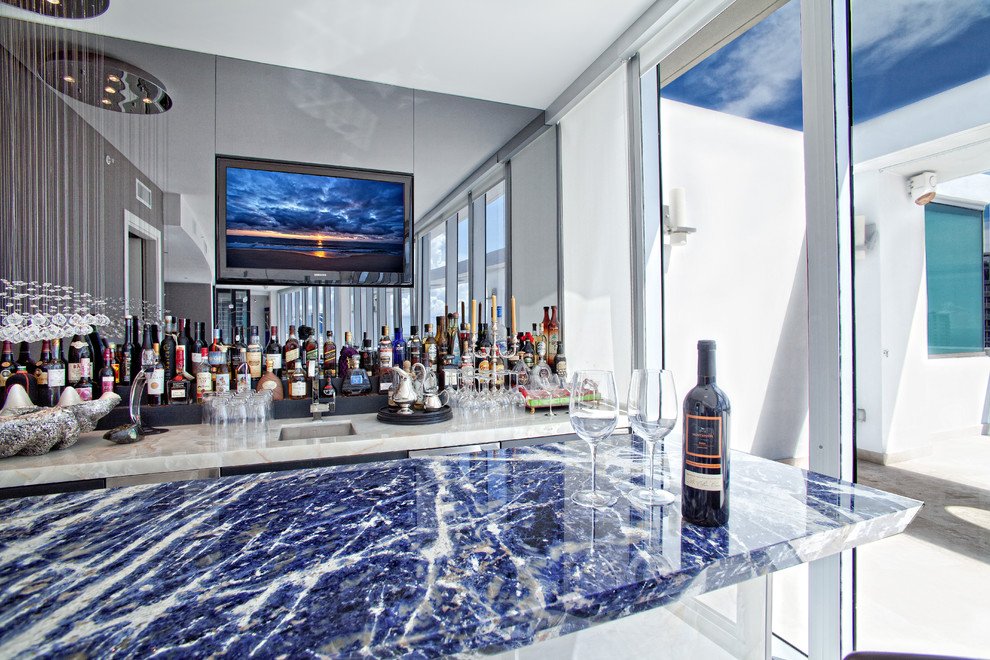 Cette image montre un grand bar de salon avec évier linéaire traditionnel avec un évier encastré, un plan de travail en granite, une crédence miroir, un sol en marbre et un plan de travail bleu.