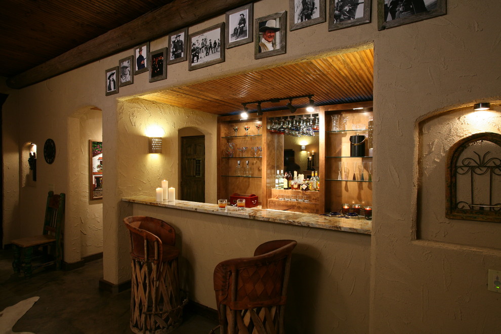 Modelo de bar en casa de estilo americano con armarios abiertos, puertas de armario de madera oscura, encimera de granito, salpicadero de azulejos de piedra y suelo de cemento