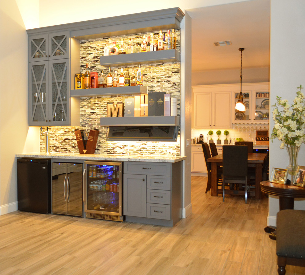 Design ideas for a medium sized traditional single-wall home bar in Phoenix with shaker cabinets, grey cabinets and light hardwood flooring.