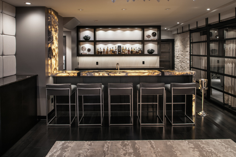 Immagine di un bancone bar moderno di medie dimensioni con ante nere, top in onice, pavimento in legno verniciato, pavimento nero e nessun'anta