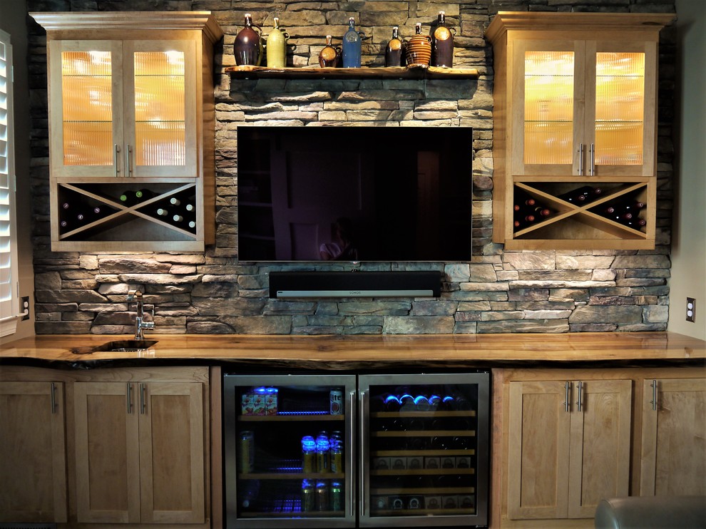 Inspiration for a small rustic dark wood floor and brown floor wet bar remodel in Raleigh with an undermount sink, glass-front cabinets, light wood cabinets, wood countertops, gray backsplash and stone slab backsplash