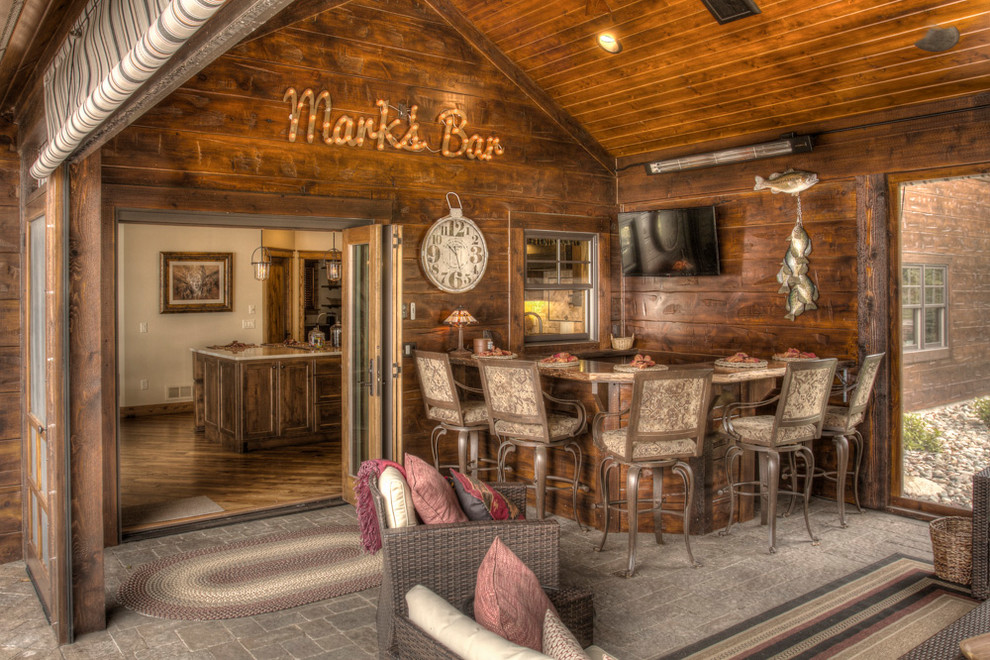 Imagen de bar en casa con barra de bar en L rural de tamaño medio con suelo de cemento y suelo gris