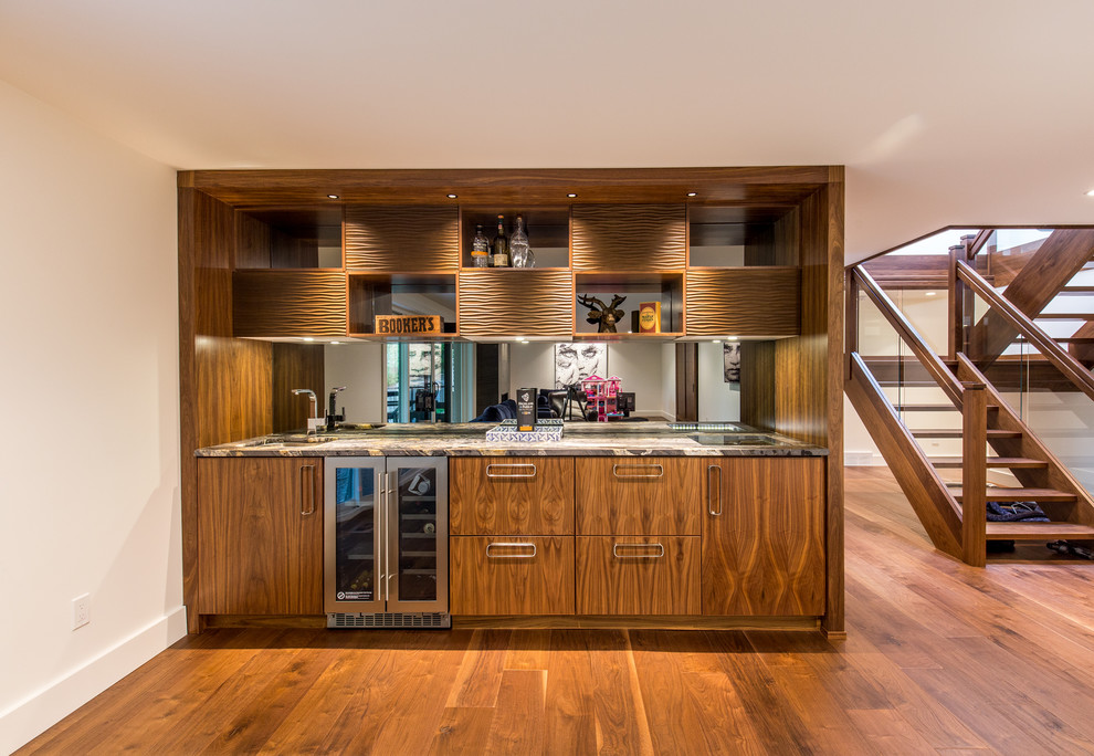 This is an example of a medium sized contemporary single-wall wet bar in Toronto with a submerged sink, flat-panel cabinets, medium wood cabinets, granite worktops, mirror splashback, medium hardwood flooring and brown floors.