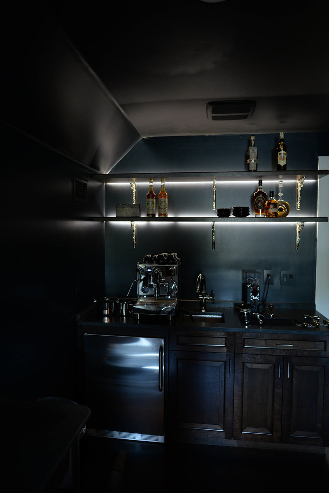 Inspiration pour un bar de salon avec évier linéaire traditionnel en bois foncé de taille moyenne avec un évier encastré, un placard avec porte à panneau surélevé et une crédence noire.