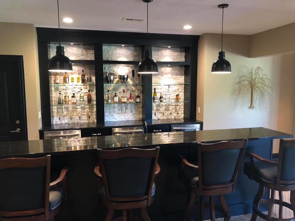 Inspiration for a mid-sized timeless single-wall seated home bar remodel in Other with granite countertops and black countertops